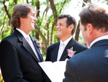 Two handsome gay grooms getting married  in beautiful park-like setting.  