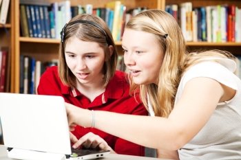 Teen girls using a computer in the library.  