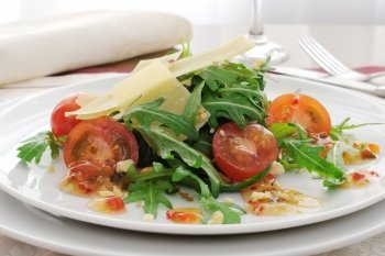 Spicy salad of arugula and cherry tomatoes with parmesan sauce