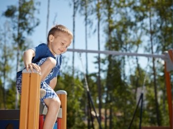 Six year old boy climbing on playground