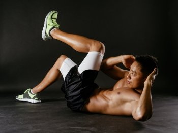 Photo of an Asian male exercising his abdominal muscles. 
