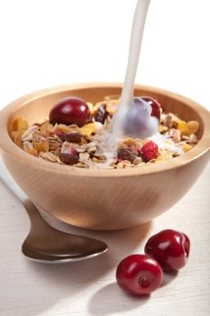 milk pouring onto cereal with fresh berries isolated
