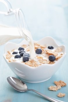 milk pouring onto cornflakes with blueberry