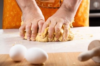 chef hands kneading dough in kitchen