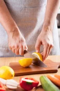 chef hands cutting lemon in kitchen
