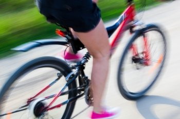 Active woman on a bike trip during summer. Lens blur