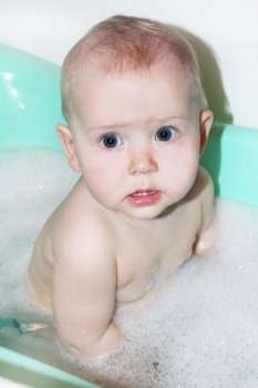 amusing face of little baby which takes a bath. little baby takes a bath