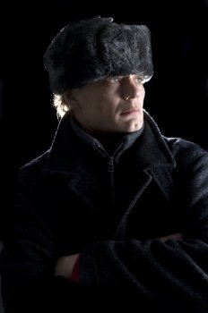 A man, dressed in Soviet attire looking away from the camera