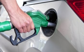 Hand, refuelling a passenger car, holding a green fuel pump