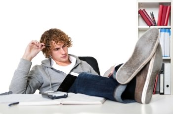 Young man studying with his feet on his desk