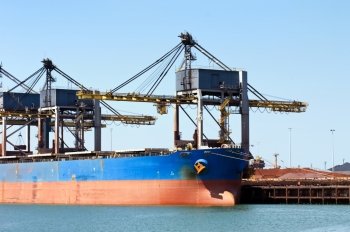Huge cranes unloading ore from a bulk carrier