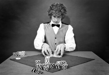 A dealer shuffling cards at a poker table