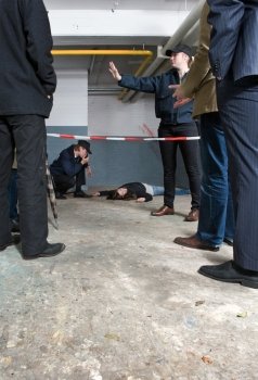 Bystanders looking at a crime scene with a murdered woman
