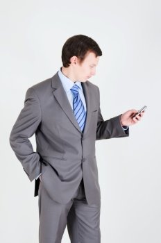 Young businessman with mobile phone and his hand in the pocket