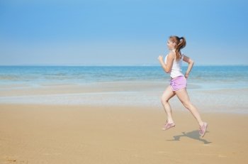 Attractive young woman running alone on the beach