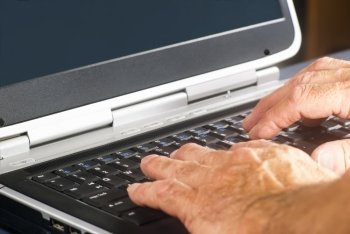 Hands typing on a flat laptop computer keyboard.