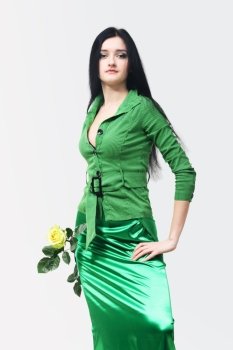 Young beautiful girl in green with a yellow rose on tne white background
