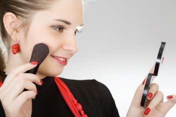 The young beautiful girl does a make-up on the person
