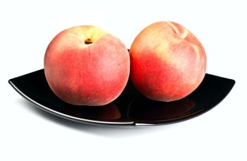 red peaches on black dish isolated on white