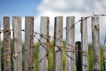 old wooden fence with rusted barbed wire
