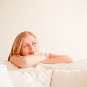 cute young woman dreaming on couch at home