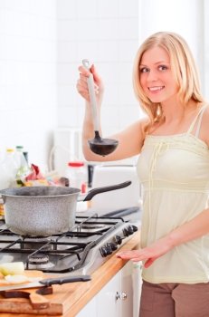 cute young woman cooking in bright kitchen
