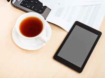 business workflow - above view cup of tea and tablet pc on office table