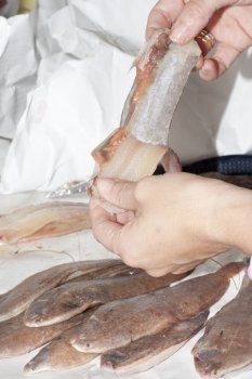 cleaning a fish in its sole fish shop for a customer
