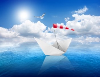 Blue calm sea and the white paper boat