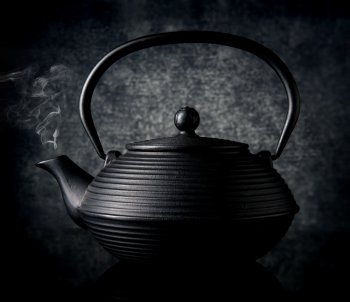 Black chinese teapot on a black background