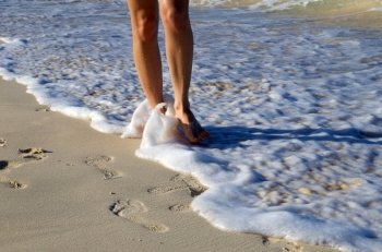Footprints in wet sand of beach