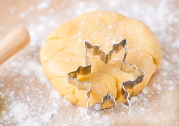 Shortcrust pastry dough with cookie cutter on a floured surface, selective focus