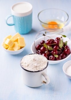 Cup of flour, butter, cherry, egg and milk. Ingredients for baking. Selective focus