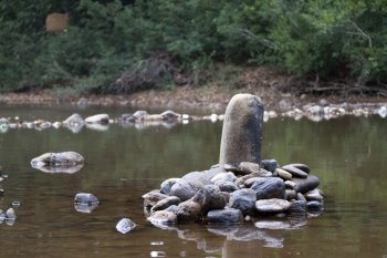 Symbol of man's advantage in a stone. India Goa. Stones in the river. India Goa.
