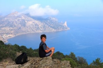 young traveler looks at the beautiful Crimean seascape from the top of the mountain, the mountain Karaul-Oba, Sudak, Crimea, Ukraine