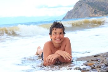 happy laughing boy of twelve on the sea beach