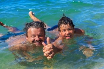 Dad and son swim in the sea