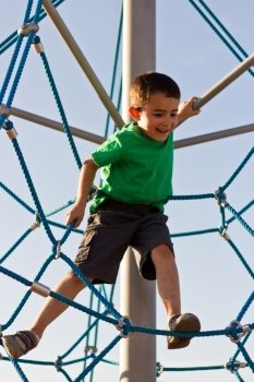 Kid having fun on the jungle gym at the playground