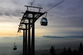 Cablecar  transports skiers to the top of the mountain and the sun goes down