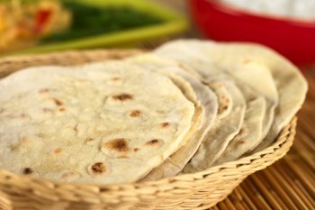 Indian flatbread called chapati in basket (Selective Focus, Focus on the big brown spot on the front of the first chapati). Chapatis