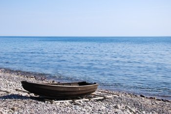 Beached old rowing boat at stony coast. From the island Oland in Sweden.