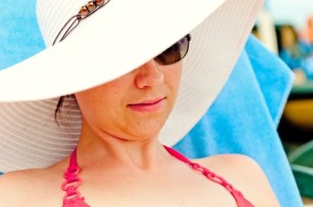 portrait of a girl in a white hat with a wide brim on the beach