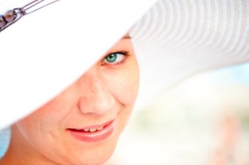 close-up portrait of a young charming smiling girl in a hat