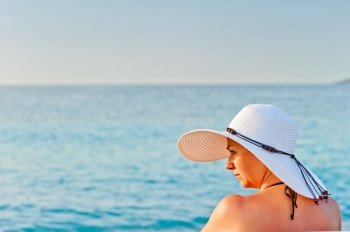 portrait of a young woman in a white hat on a background of the sea