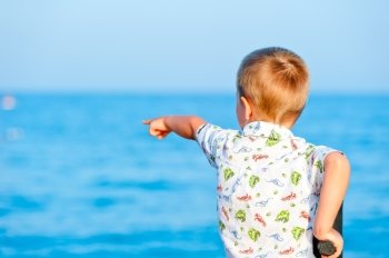 child points to something in the sea