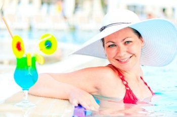 girl in the pool in a white hat smiling