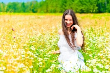 smiling girl in camomile field rests