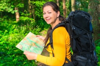 happy traveler with a map in the forest