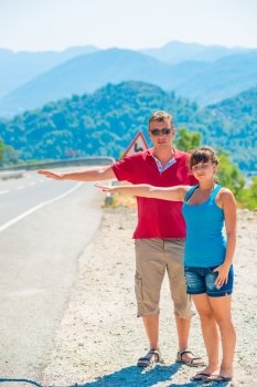 married young couple hitchhiking summer day