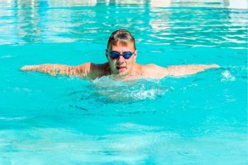 male athlete swimming butterfly stroke in a swimming pool